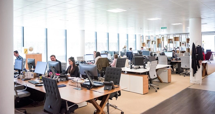 An office with a team working on computers exploring the benefits of professional services automation.